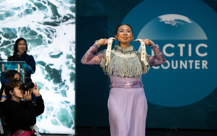 Margaret Thomas, bottom left, photographs a model at the Arctic Encounter Symposium fashion show. Photo courtesy of Thomas.