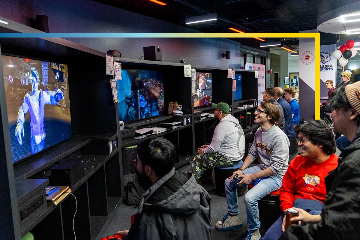 A gourp of students play console games at the TVs in the Esports Center