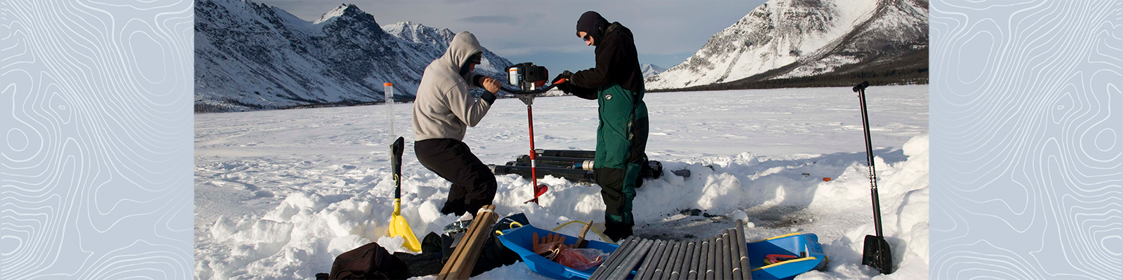 Two researchers working on a snow covered mountain