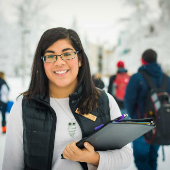 UAF student holding books outside in winter