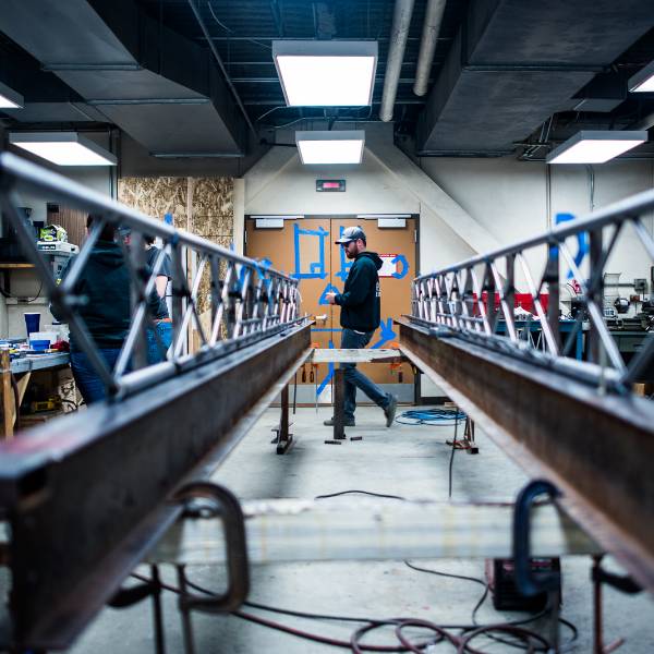 UAF engineering student walking past model steel bridge