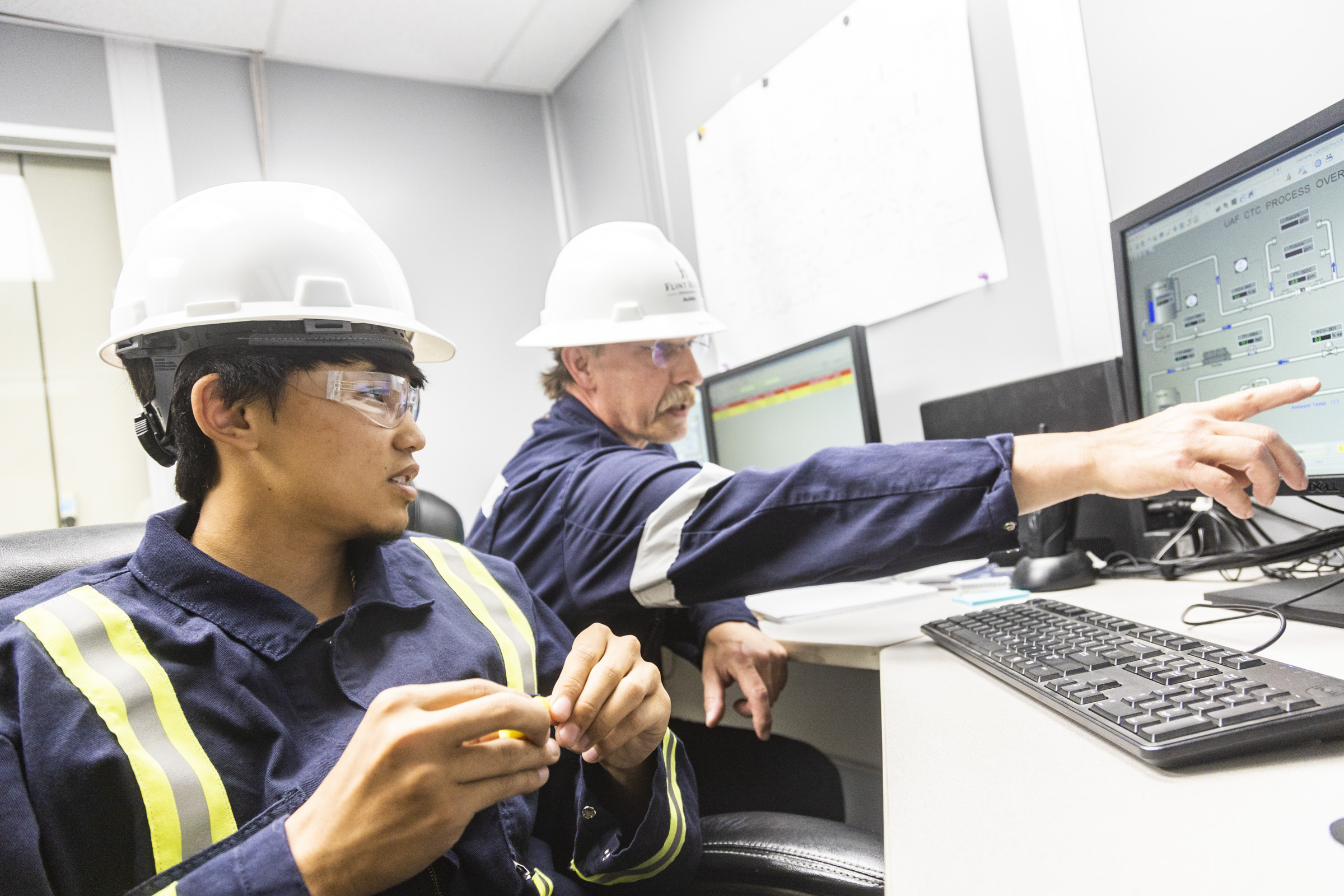 A student from the Rural Alaska Honors Institute works on a simulator with an instructor at the Fairbanks Pipeline Training Center. UAF photo by JR Ancheta.