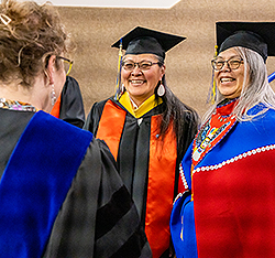 Two graduates smiling. Links to Gifts by Will.