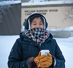 A woman in winter clothing holding a cup of coffee. Links to Gifts from Retirement Plans.