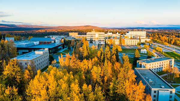 East facing aerial view of UAF campus with autumn trees in the foreground and the Gruening Building in the background