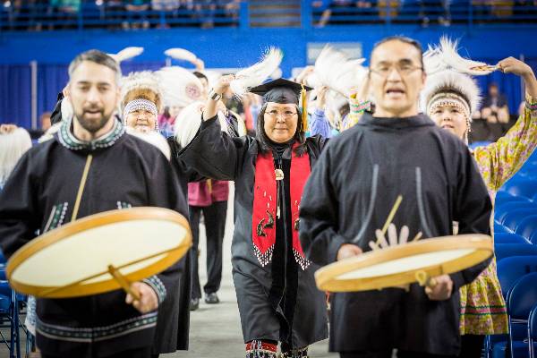 An Alaska Native dance group lead the procession at the UAF commencement ceremony