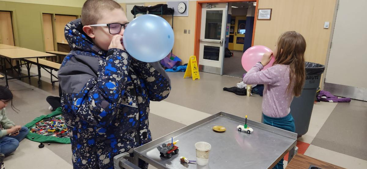 Two people blowing up balloons