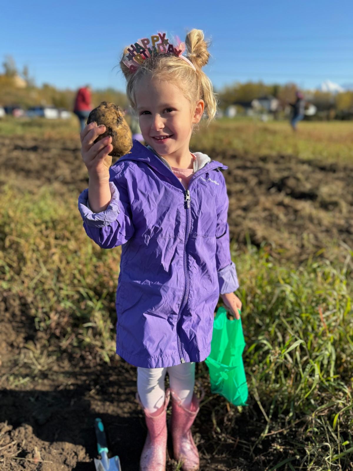 Girl smiling holding potato