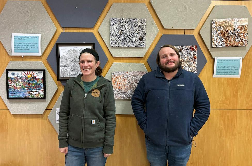 Two researchers standing in front of artwork