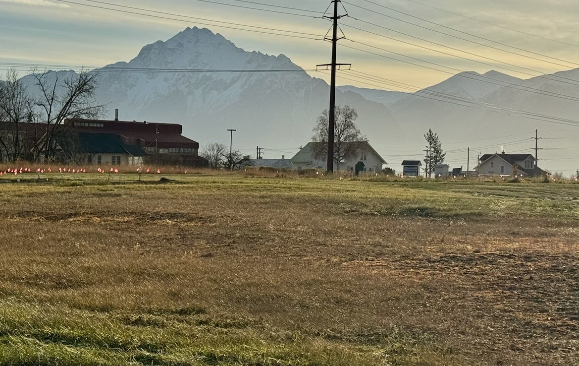 View of buildings across field under a view of mountains