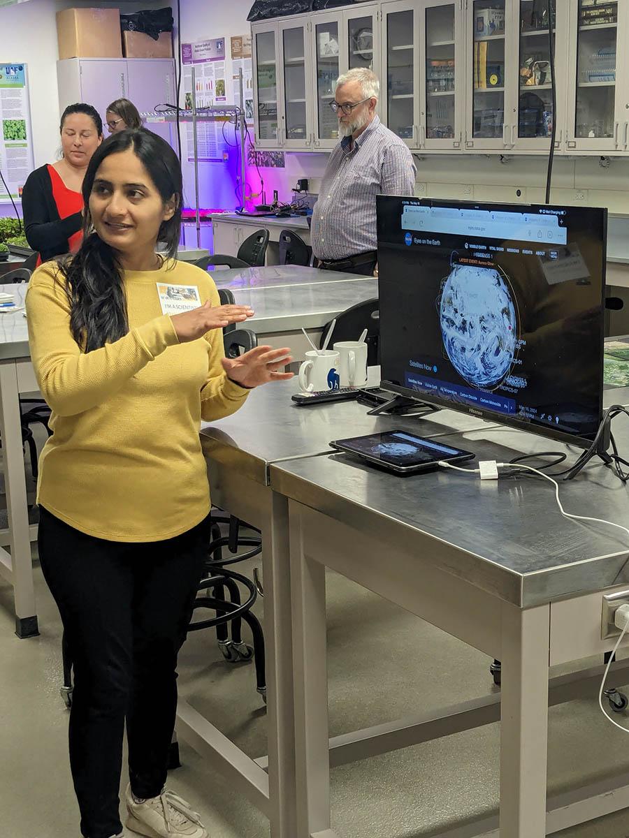 Woman gesturing to a monitor