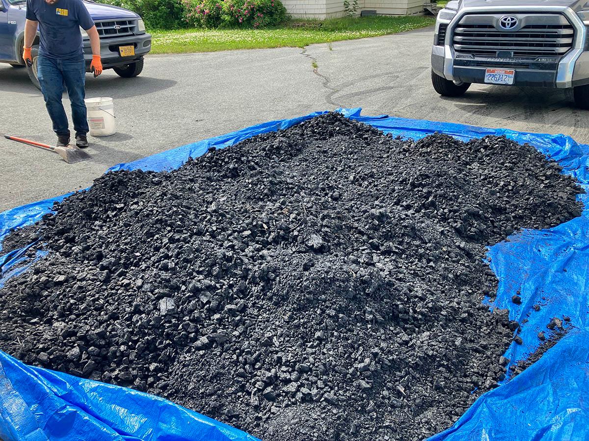Piles of biochar on a blue tarp