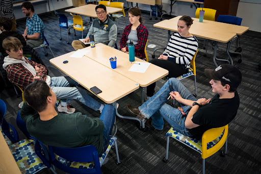 a group of people sitting around the table 