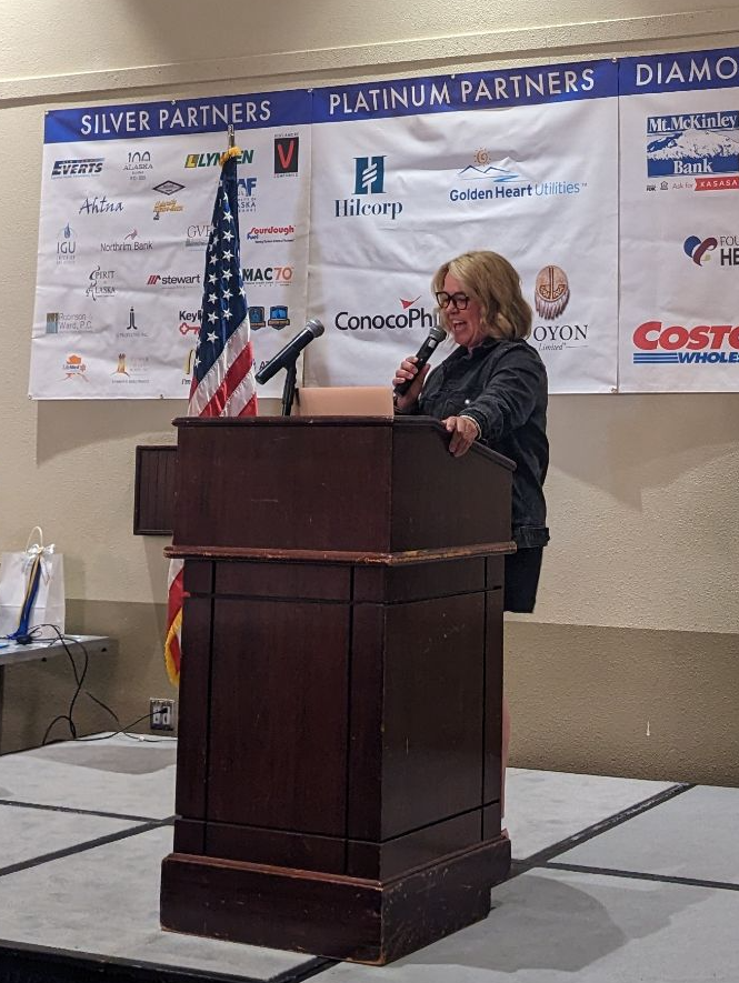 A woman stands behind a podium 