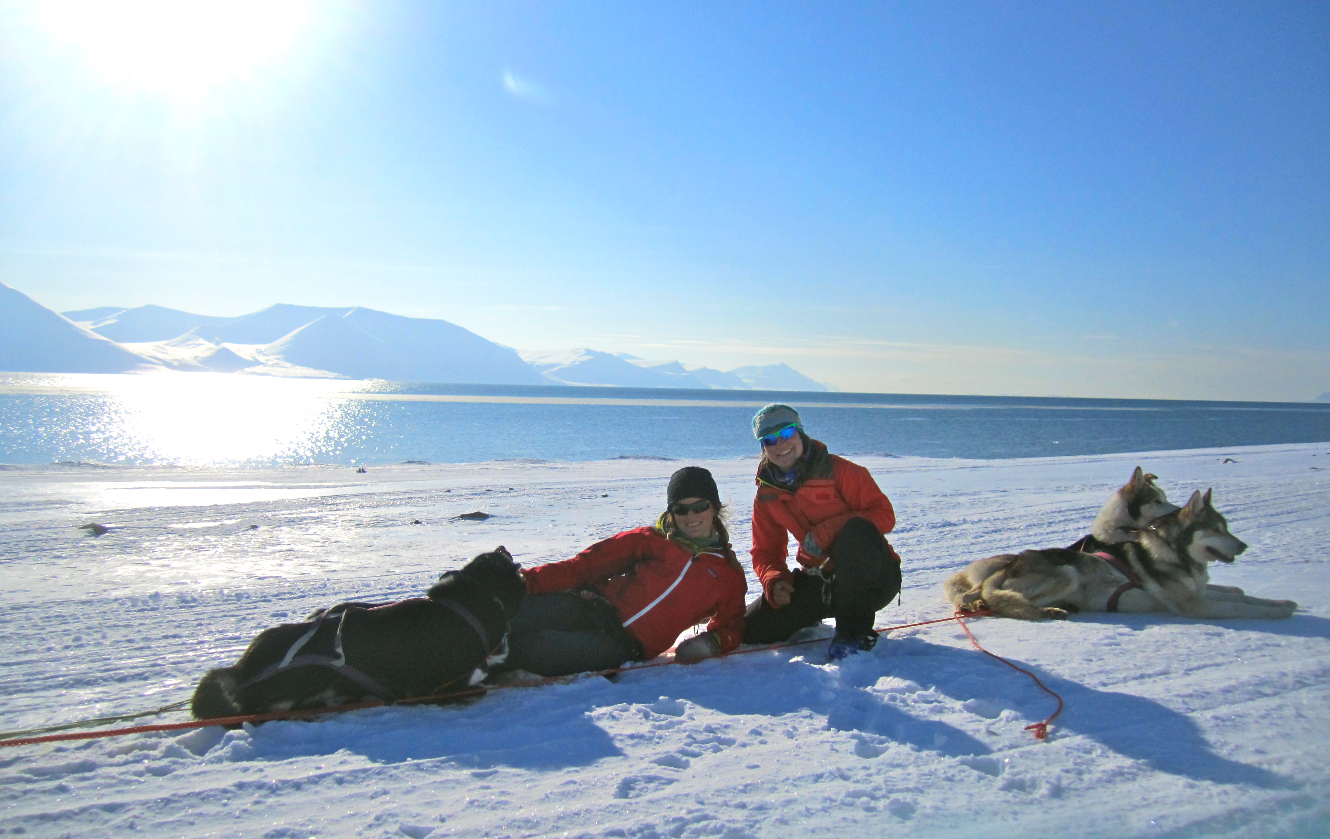Researchers laying in snow in a remote area of Alaska