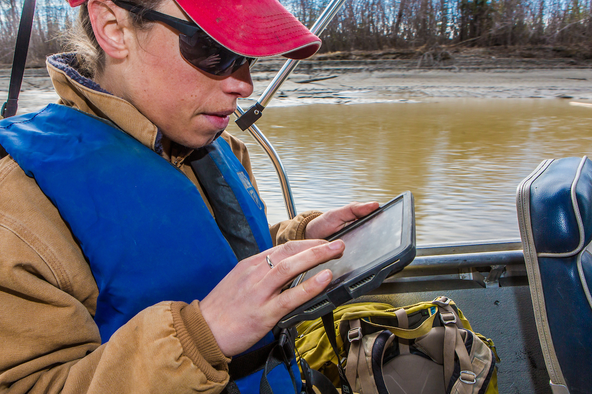 Shalane Frost, a research assistant with UAF's Institute of Arctic Biology, uses an iPad to track locations while on a data gathering boat trip into the Bonanza Creek Long-Term Ecological Research area about 25 miles southwest of Fairbanks along the Tanana River. | UAF Photo by Todd Paris