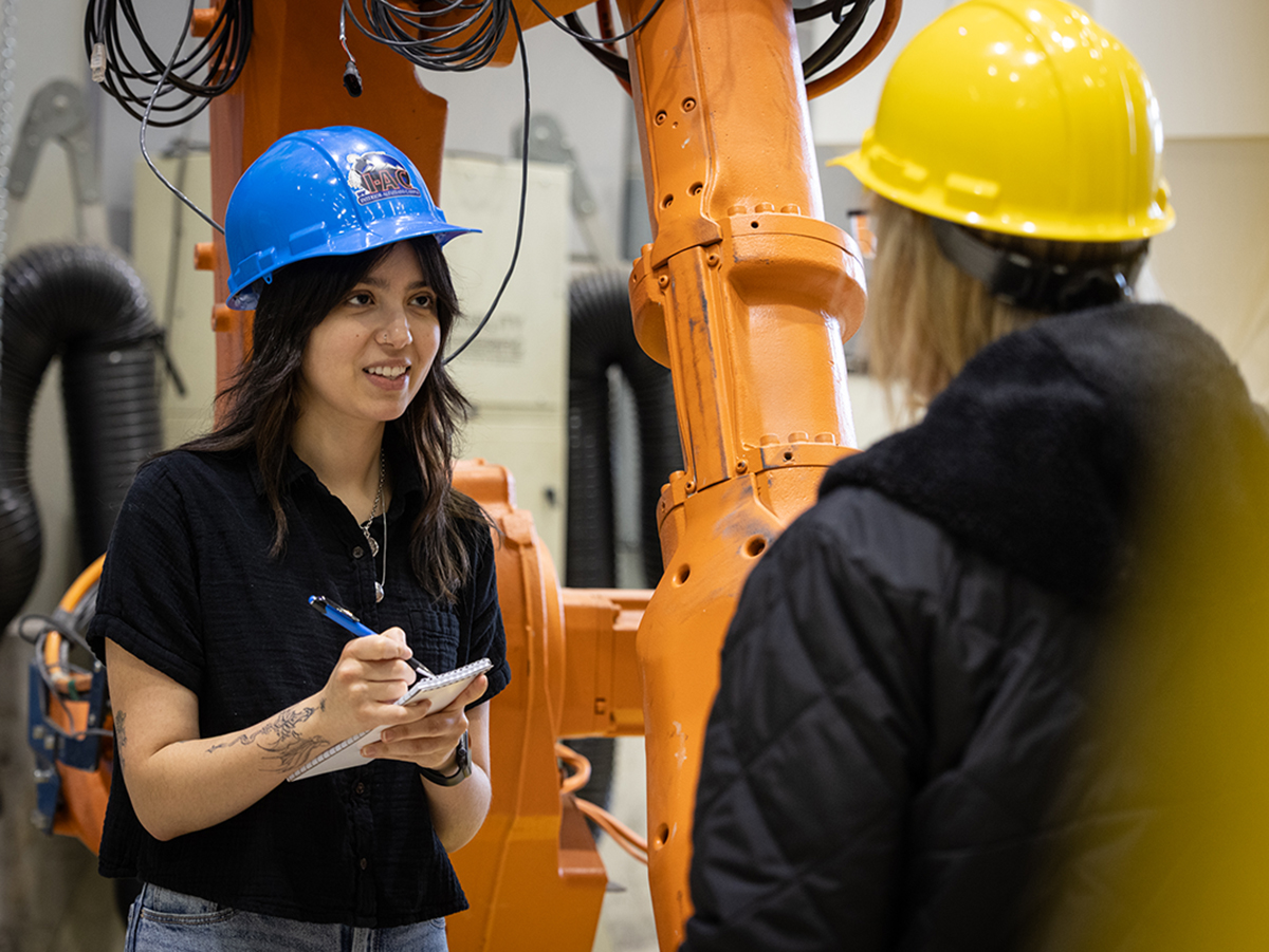 A journalism student interviews a scientist during a department photo shoot, April 2026. UAF Photo by Charles Mason.