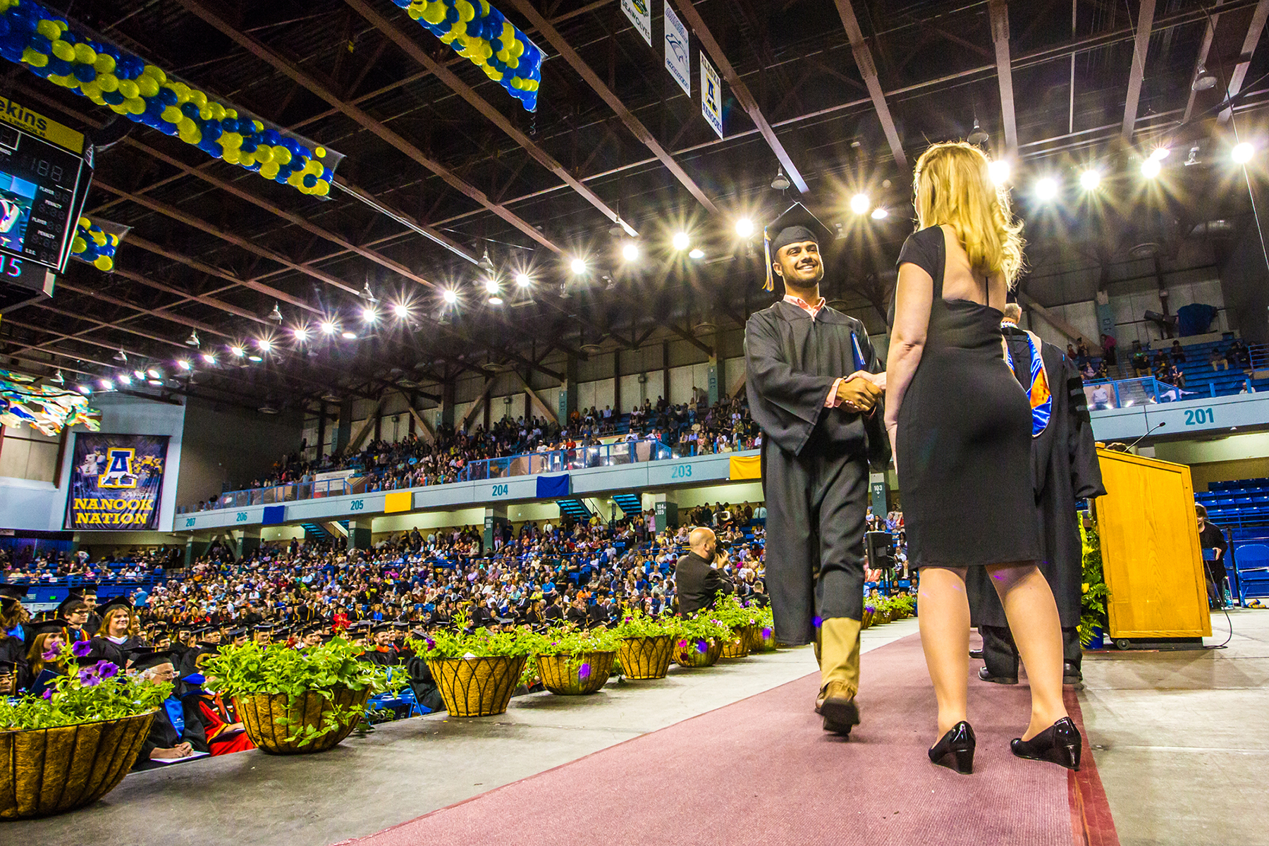 Andrew Heckman shakes hands with UAF Alumni Association representative Rhonda Widener after earning a degree in Justice during UAF's 2015 commencement ceremony. | UAF photo by Todd Paris