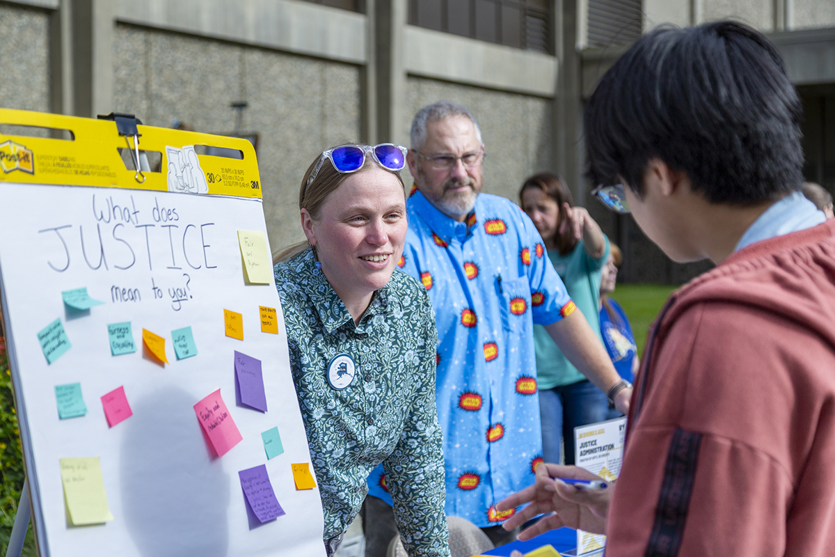 Drs. Ingrid Johnson and Derik Stone speak with a nw student at UAF's 2025 Party in the Park. UAF Photo by Sarah Manriquez
