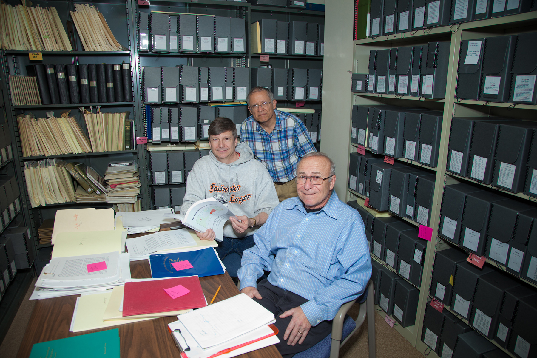Native linguists Jim Kari, front, Edward Vajda, center and Larry Kaplan pose with a recently published volume outlining research which establishes an ancient language connection between people of Asia and North America. | UAF Photo by Todd Paris