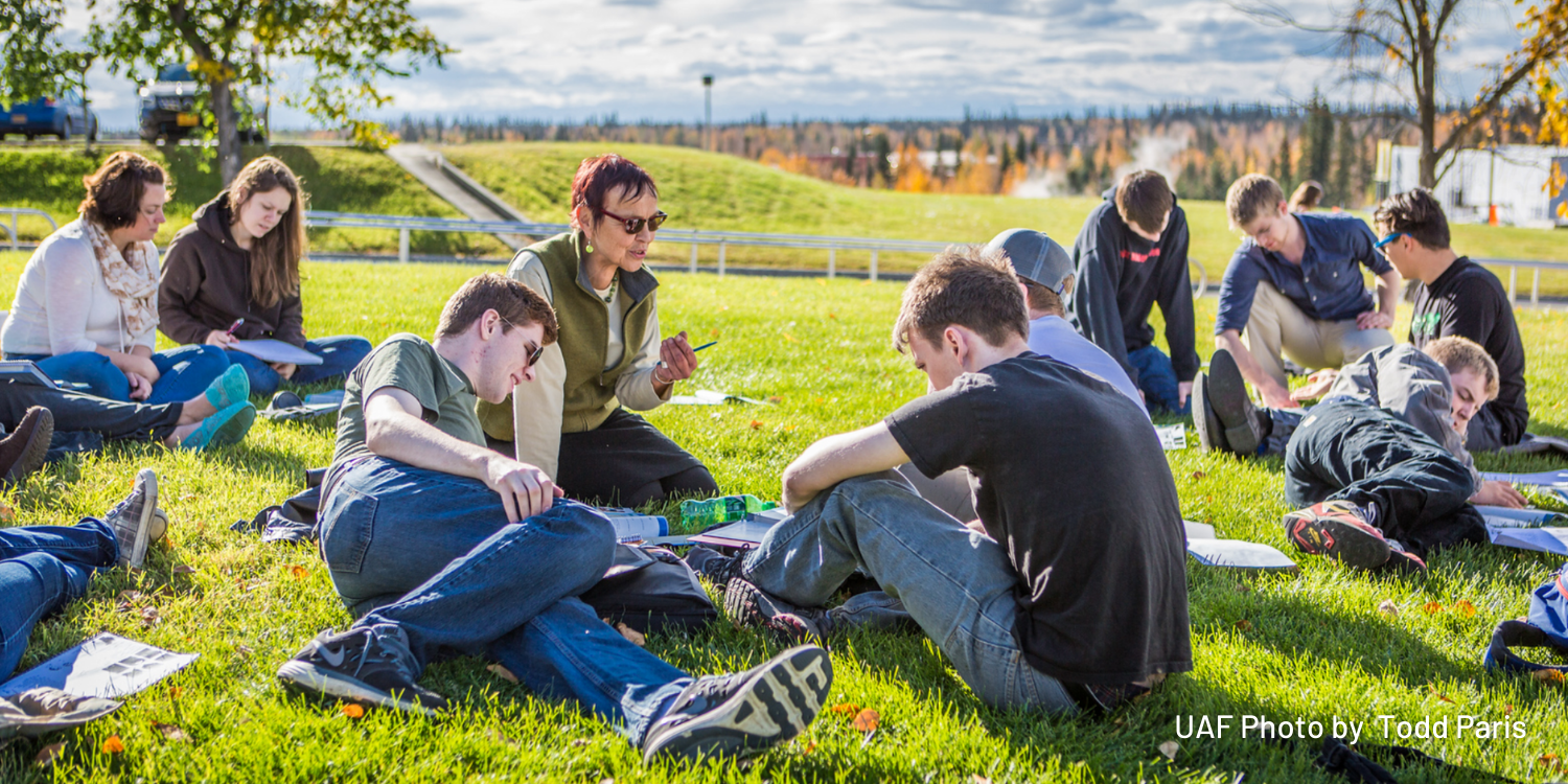 A German foreign language class holds class on the campus lawn during a warm autumn afternoon.