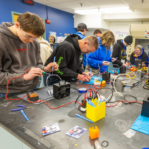 Students gathered in a Makerspace soldering