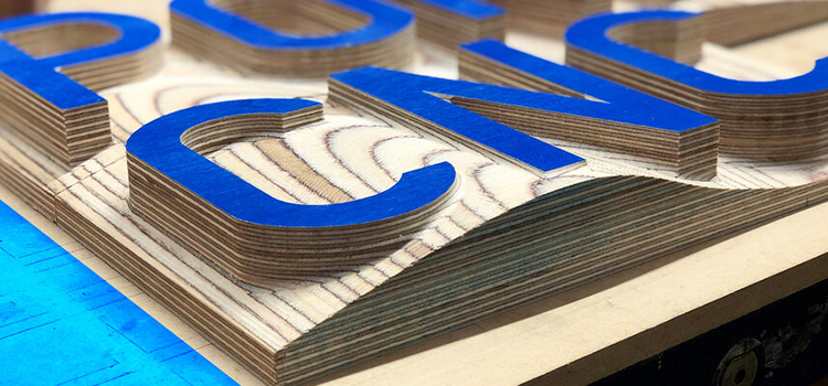 Closeup of letters engraved in wood by the 3-axis Desktop CNC