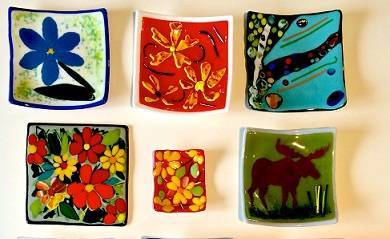 Six fused glass plates with various designs.