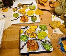 Several colorful leaves, next to a painting of the same leaves.