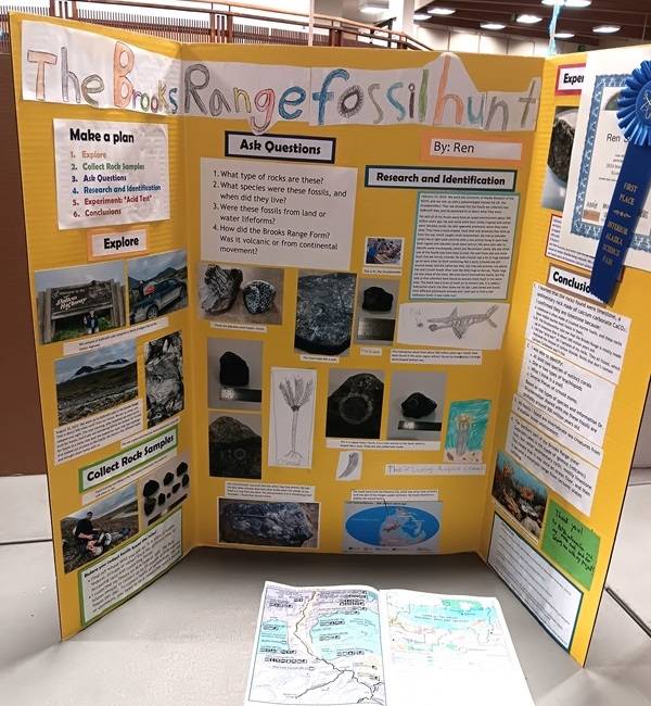 Yellow Science Fair posterboard with the title "The Brooks Range Fossil Hunt" and several photos of fossils.