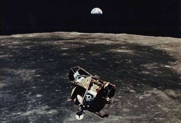 An artist's drawing of the Apollo shuttle orbiting the moon and seeing Earth rise over the horizon.