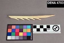 Antler projectile point on a gray background, with a centimeter ruler and color card for reference.