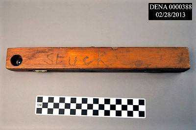 Wooden case for a thermometer. The word "Stuck" is carved on the outside.