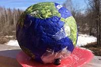 A blue and green paper mache Earth.