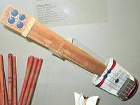 Toy guitar made of a piece of wood and an aluminum can.