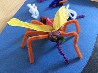 Model of a mosquito, made with pipe cleaners, tissue paper, and clay.