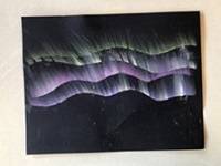 Black construction paper with colorful chalk lines representing the aurora.