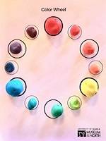 Twelve small circles arranged in a larger circle. A small ball of play dough, each a different color, is sitting in each circle.