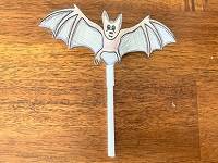 Cut-out drawing of a bat, with a straw attached to the bottom.