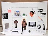 Mini museum exhibit example, with cutouts of various museum objects glued to a piece of cardstock folded into thirds.