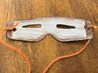 Snow goggles template with a piece of yarn tied through each side.