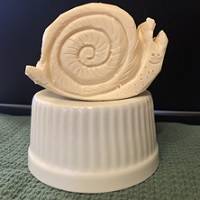 A figure of a snail carved from a bar of soap.