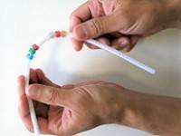 Hand threading beads on a pipecleaner,