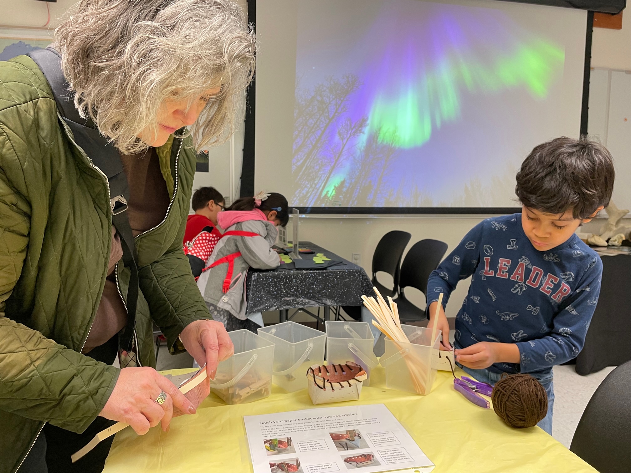 Child and adult making a paper basket