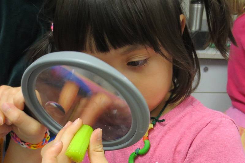 Child looking through a magnifying glass.