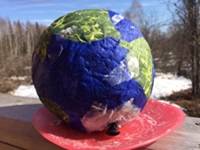 A blue and green paper mache Earth.