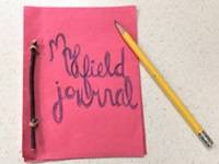 Homemade field journal made out of red construction paper, with the words "My field journal" on the cover.