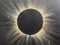 Black construction paper with yellow and orange chalk lines radiating out from a circle in the center.