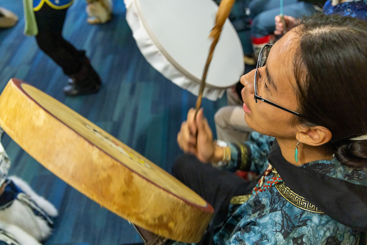 Naatanii Mayo plays a drum along Troth Yeddha' & Iñu-Yupiaq dance groups in celebration of Indigenous Peoples Day in the Wood Center Multi-Level Lounge on October 14, 2024. UAF Photo by Marina Barbosa Santos