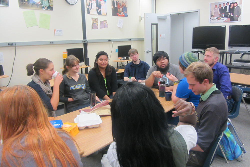 French Club students gathered around a table enjoying food together